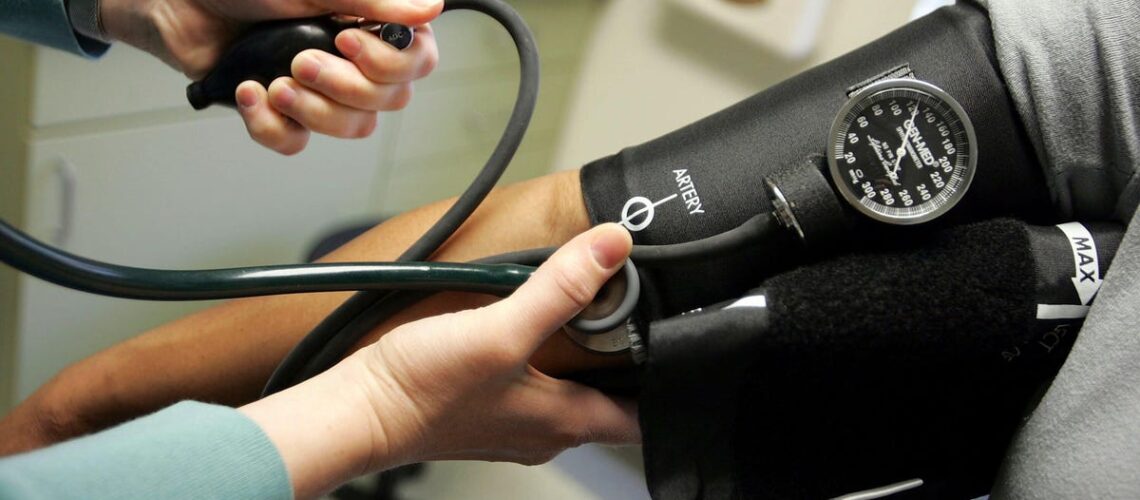 A doctor takes a patient&apos;s blood pressure