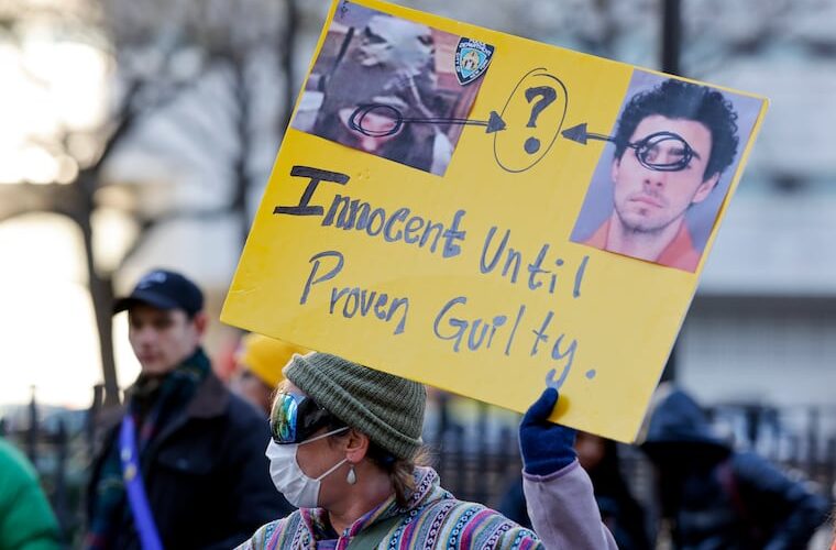 A demonstrator holds up a sign while waiting for the arrival of Luigi Mangione for his arraignment at Manhattan Criminal Court on Monday, Dec. 23, 2024, in New York.