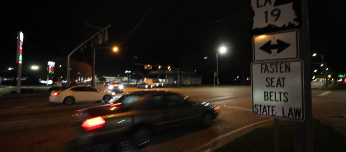 Vehicles travel down roadway at night